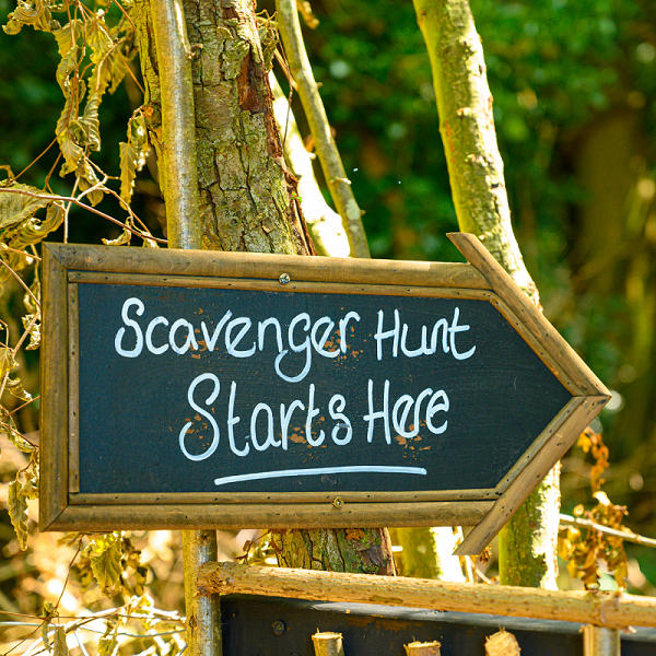 Scavenger Hunt Starts here arrow sign with trees behind it.